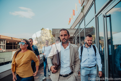 Image of A diverse group of businessmen and colleagues walking together by their workplace, showcasing collaboration and teamwork in the company.