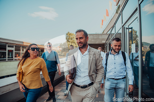 Image of A diverse group of businessmen and colleagues walking together by their workplace, showcasing collaboration and teamwork in the company.