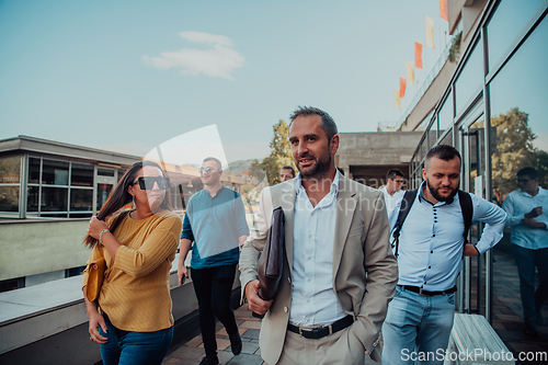 Image of A diverse group of businessmen and colleagues walking together by their workplace, showcasing collaboration and teamwork in the company.