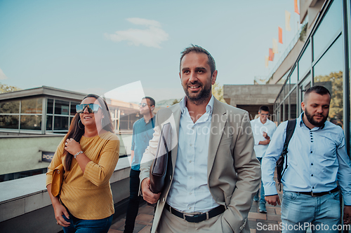 Image of A diverse group of businessmen and colleagues walking together by their workplace, showcasing collaboration and teamwork in the company.