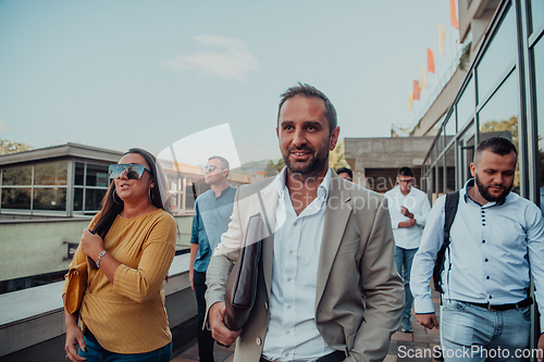 Image of A diverse group of businessmen and colleagues walking together by their workplace, showcasing collaboration and teamwork in the company.