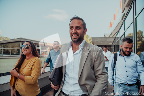 Image of A diverse group of businessmen and colleagues walking together by their workplace, showcasing collaboration and teamwork in the company.