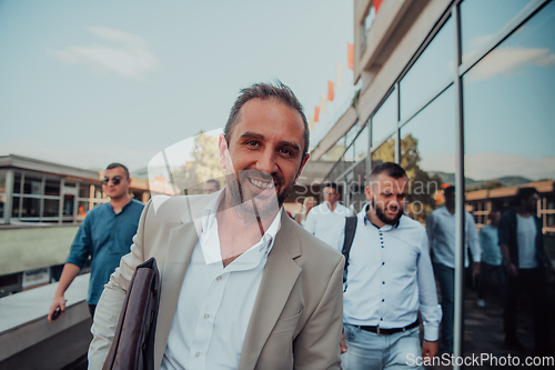 Image of A diverse group of businessmen and colleagues walking together by their workplace, showcasing collaboration and teamwork in the company.