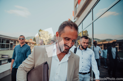 Image of A diverse group of businessmen and colleagues walking together by their workplace, showcasing collaboration and teamwork in the company.