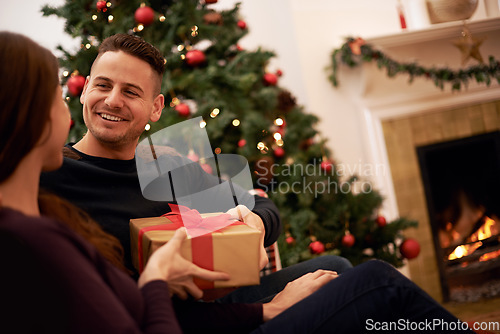 Image of Christmas, gift and happy family celebration of a man with a present at a holiday party. Couple with love and care on the holidays together with gifting box feeling happiness with a smile at home