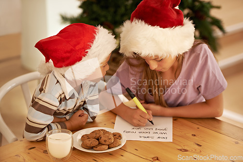 Image of Children, writing and letter to santa at a table with brother and sister planning wishlist for christmas with milk and cookies. Kids, hope and list on paper for festive spirit, fantasy and xmas hope