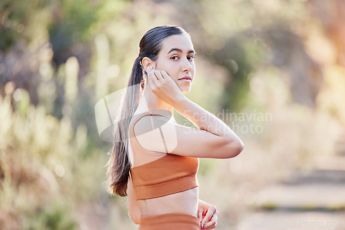 Image of Fitness portrait, earphones and woman in nature streaming podcast, radio or motivation music for running. Sports, healthcare and female from Canada listening to audio and getting ready for training.