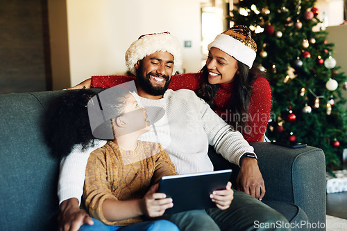 Image of Christmas, family and tablet on sofa in home streaming movie or internet browsing. Xmas, love and girl, father and mother with digital touchscreen bonding, caring and enjoying holiday time together.