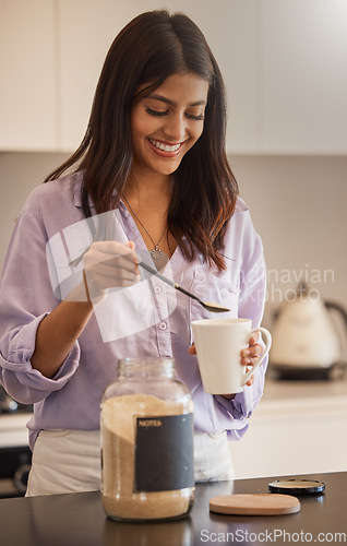 Image of Woman, smile and morning making coffee in the kitchen for routine, start or daily preparation at home. Female smiling and adding sugar to mug for sweet warm beverage drink or caffeine at the house