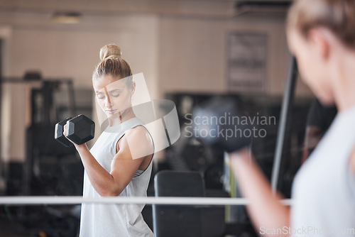 Image of Woman, bodybuilder and gym with dumbbell, focus or fitness for health, muscle or development. Girl, bodybuilding and exercise for wellness, strong body or workout in mirror, motivation or inspiration