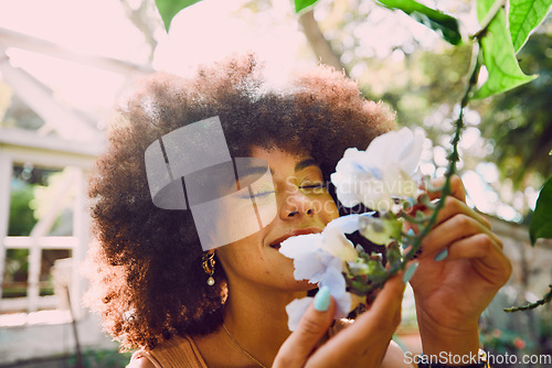 Image of Woman, smell flowers and spring garden enviroment for plants wellness or sustainability. African person, green energy and smelling floral fragrance or gardening, ecology and happiness in nature