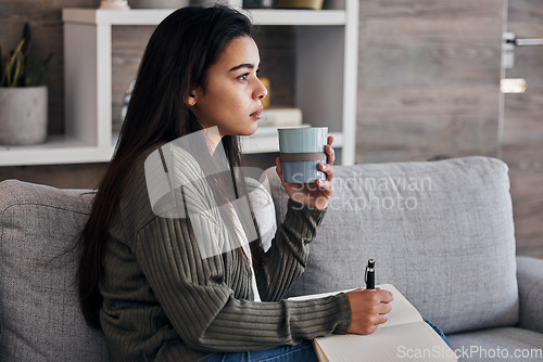 Image of Relax, thinking and woman journaling with coffee for self care on the living room sofa of her house. Idea, tea and girl with creativity in a notebook, green tea and writing in diary on the couch