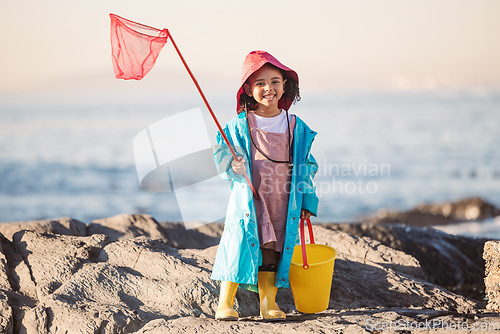 Image of Child, kid or girl portrait with fishing bucket and net at beach, ocean or sea to fish in summer. Happy black child outdoor learning for salt water shrimp, crabs or fish with smile in holiday