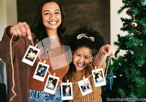 Image of Christmas, decoration and mother and girl with Polaroid on a tree for love, happiness and celebration of holiday in a house. Festive, happy and portrait of a mom and child show picture for decorating