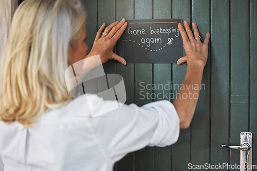 Image of Hands, sign and beekeeping with a woman farmer hanging a note on her door before leaving to go farm. Wood, agriculture and small business with a female beekeeper outdoor for the production of honey