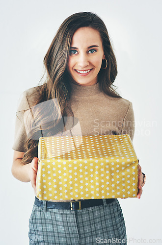 Image of Gift, woman and present for celebration, christmas or birthday on a studio background for happiness, giving and kindness. Portrait of a model with gift box to celebrate surprise holiday mockup