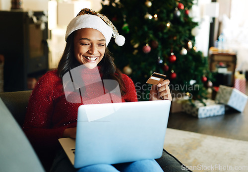 Image of Credit card, laptop and woman online shopping on Christmas day in living room. Fintech, xmas holiday and happy female from India on computer, virtual store or internet shop buying gifts or presents.