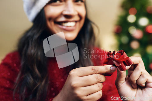 Image of Christmas, ribbon and woman wrapping gifts for a holiday party, event or dinner at home. Happy, excited and girl with a smile holding bow for festive decoration for xmas celebration presents at house