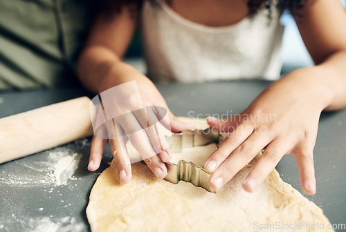 Image of Family, hands baking and christmas tree cookies being made with a cutter while bonding and learning. Sweets, dessert and biscuit treat being baked with dough by a child and her parent at xmas
