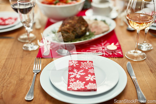 Image of Wine glass, plate and cutlery on the table at a christmas party or event in the dining room of a house. Napkin, table setting and dinner party for a festive xmas holiday lunch celebration at a home.