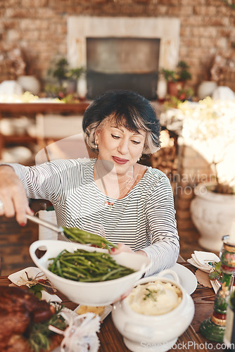 Image of Thanksgiving table and senior woman with vegetables serving at food party for USA celebration. Holiday, celebrate and mature festive person at home dining table with green beans for nutrition.