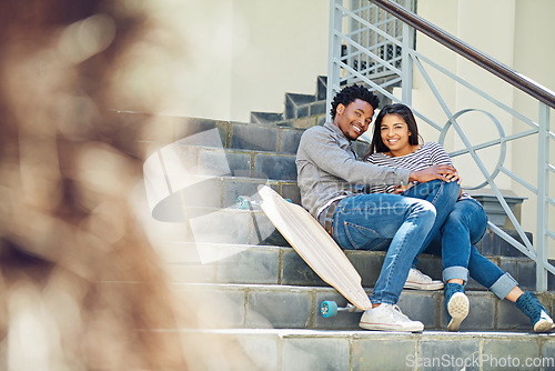 Image of Couple, happy and skateboard while sitting on stairs with hug, love and romance in city sunshine. Black couple, urban happiness and outdoor with skater, embrace and romance on steps in San Francisco