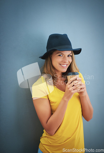Image of Woman, fashion or coffee cup on blue background studio and marketing mockup, advertising space or mock up branding. Portrait, smile or happy student and takeaway hot drink, trend hat or style clothes