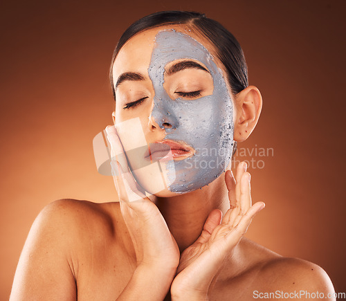 Image of Skincare face, woman and mask for beauty, charcoal cosmetics cleaning and skin wellness treatment. Healthy face mask, natural facial dermatology and luxury spa makeup in orange studio background