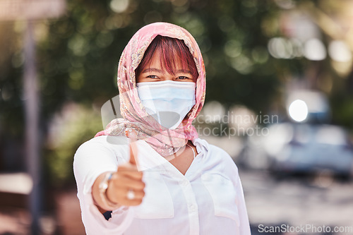 Image of Success, hijab and woman thumbs up with covid protection on Turkey, Europe holiday walk in town. Yes, agreement and vacation of muslim travel person walking with face mask for corona safety.