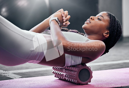 Image of Fitness, exercise and foam roller with a black woman in gym, training during a workout for health. Yoga, wellness and pilates with a female athlete exercising in a sports club for physiotherapy