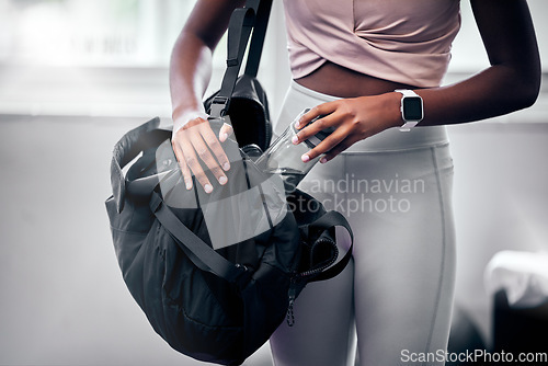 Image of Woman, gym and water bottle in bag, hand and hydration at workout, training and fitness class. Black woman, exercise and gym bag for health, self care and wellness with drinking water in Los Angeles