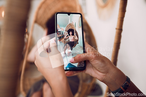 Image of Hands, phone and fashion with a designer taking a photograph of a model black woman in a swing chair. Smartphone, photography and style with an edgy female on screen or display of a design employee