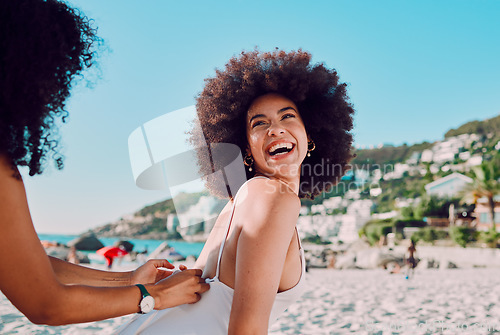 Image of Sunscreen, black woman and friends at a beach for a happy vacation or holiday to relax with freedom in Miami. Smile, travel and women helping a young gen z girl with skincare cream on back at sea