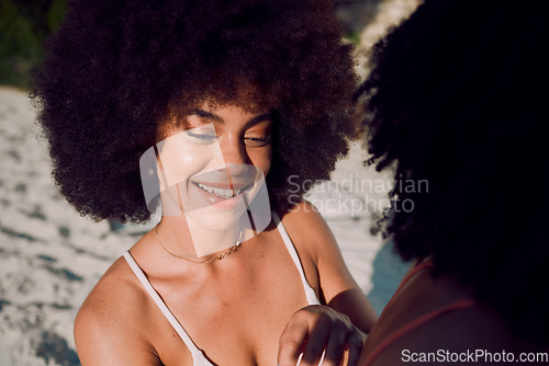 Image of Sunscreen, skincare and black woman at a beach with friends applying beauty cosmetics on back in Hawaii. Women, relax or happy African girl helping a person with spf protection cream or lotion at sea