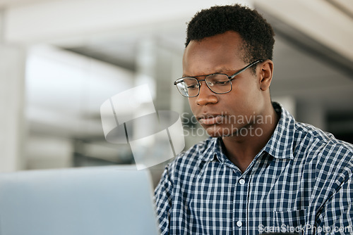 Image of Thinking, black man and laptop for business, online reading and search internet in office. Young male, entrepreneur and computer for trading, concentration or focus for research, stress and workplace