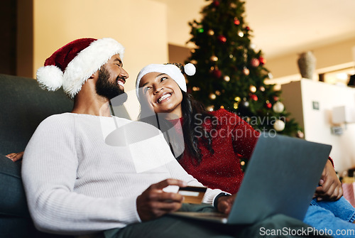 Image of Christmas, couple and laptop on sofa, credit card or happiness together, ecommerce or festive season in lounge. Xmas, love or woman with man, payment, online banking or happy for transaction on couch