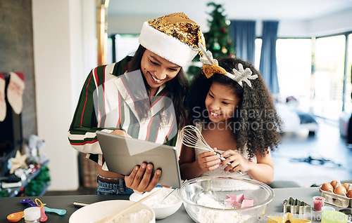 Image of Mother, child and tablet for christmas baking, cooking and holiday celebration for cookies or cake with family home wifi for app. Woman and girl or daughter learning food recipe together in kitchen