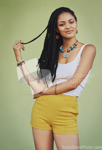 Image of Fashion, beauty and portrait of black woman on green background in studio with creative, exotic and designer jewellery. Summer, African style and happy girl with braids, cosmetics and trendy clothing