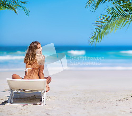 Image of Tropical, relax and woman at the beach for holiday, travel and summer by the ocean in Bali. Nature, happy and girl on a chair by the sea for an island vacation in a bikini with a smile by the water