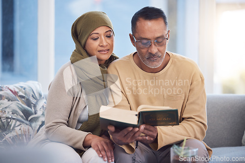 Image of Reading, book and eid mubarak with a muslim couple in the living room of their home together with the quran. God, Islam and ramadan with a man and woman bonding over religion in their house