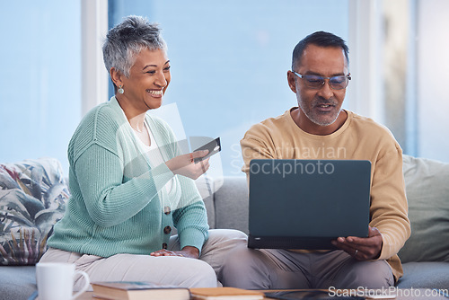 Image of Couple, laptop and credit card for ecommerce, online shopping or transaction together at home. Elderly man and woman with smile for easy internet banking on computer relaxing on living room sofa