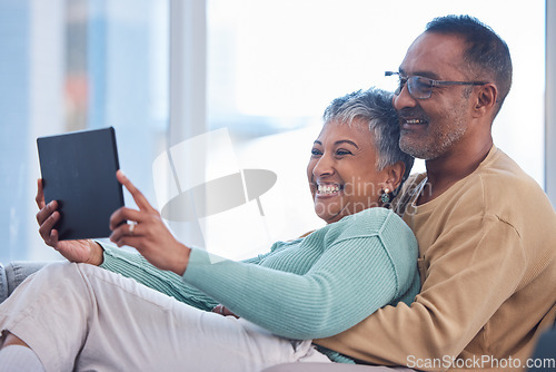 Image of Movie, communication and senior couple with a tablet, streaming film and show on the living room sofa of their house. Website, social media and elderly man and woman with comedy and app on tech