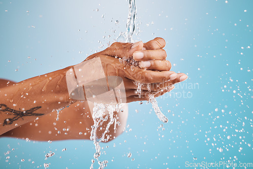 Image of Water, washing and cleaning hands on blue background for hygiene, healthcare and cleansing in studio. Wellness, hydration and person washing hands for germ protection, bacteria and safety from virus