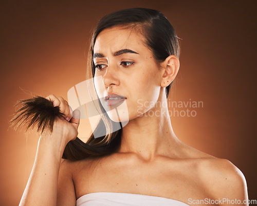 Image of Hair, keratin and treatment with a model woman in studio on a brown background for damage or split ends. Salon, haircare and shampoo with a frustrated female suffering or annoyed with her hairstyle