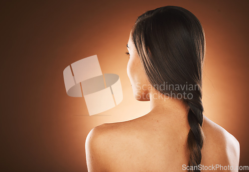 Image of Woman, back or hair style on orange background in studio in keratin treatment marketing, balayage growth advertising or self care routine. Model, texture or healthy brunette color on aesthetic mockup
