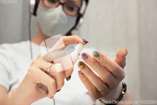 Image of Woman disinfects the surface of the phone