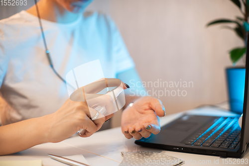 Image of Woman disinfects the surface of the phone