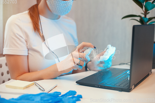 Image of Woman disinfects the surface of the phone