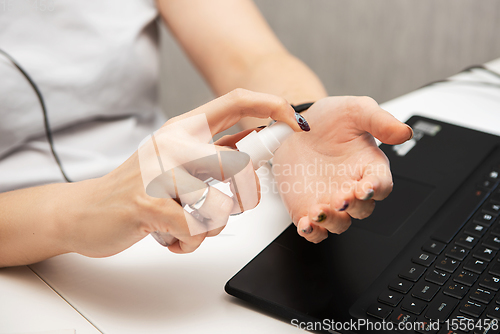 Image of Woman disinfects the surface of the phone