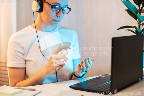 Image of Woman disinfects the surface of the phone